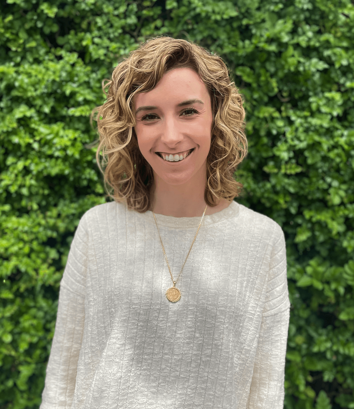 Photo of Lauren in front of green wall.