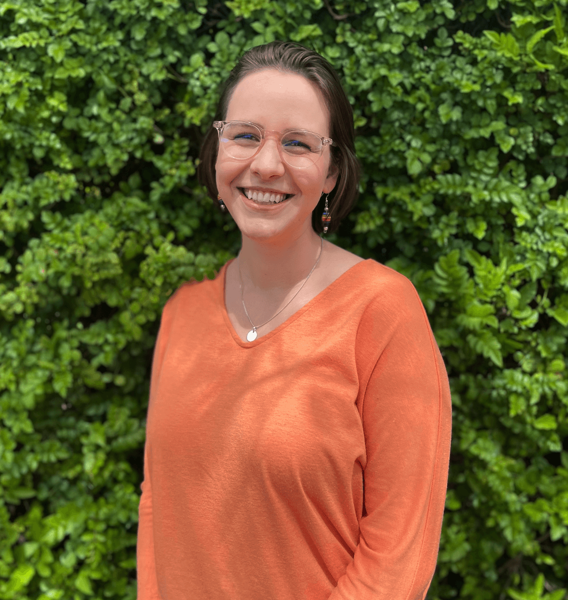 Photo of Tessa in front of green wall.