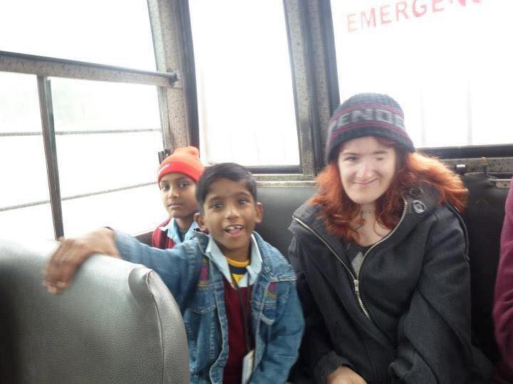 Ellen on bus with young students