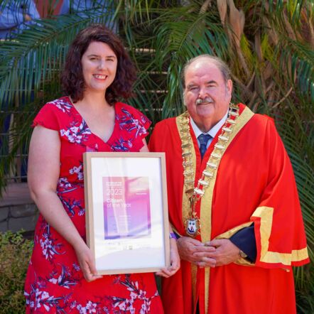 Rachel beaming at camera as she receives her Citizen of the Year award.