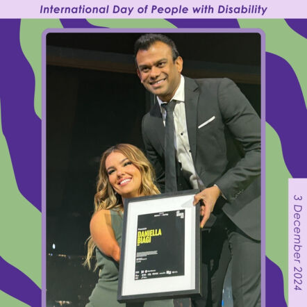 Photo of Daniella, JFA Purple Orange Board Treasurer, at the InDaily 40 Under 40 awards. She is standing next to a man with whom she is holding a framed award and posing for a photo. 