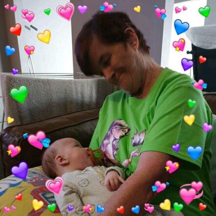 Photo of Catherine smiling down at her grandson Marlo, who is resting on a pillow on her lap.
