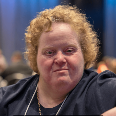 Photo of Rachel, a woman with white skin and curly light brown hair looking at camera.